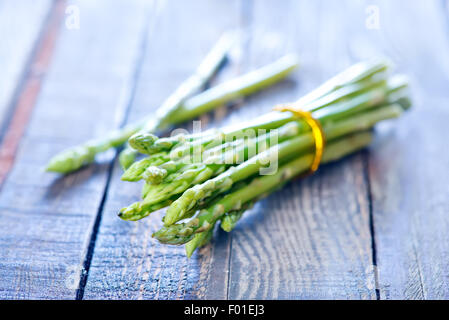 Materie asparagi sul tavolo di legno, asparagi verdi Foto Stock