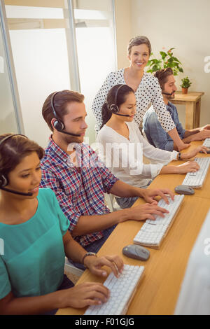 Manager che assiste il personale in call center Foto Stock