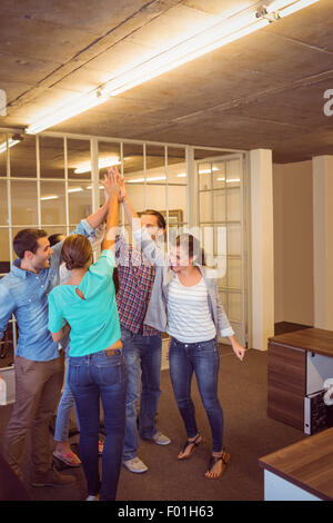 Creative team aziendali elevando le mani Foto Stock