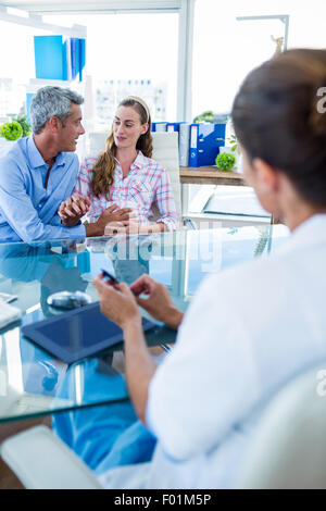 La donna incinta e il marito a discutere con il medico Foto Stock