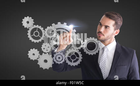 Immagine composita di pensosa imprenditore puntando qualcosa con il suo dito Foto Stock