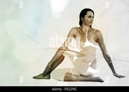 Immagine composita di montare la donna facendo la Mezza torsione spinale pongono in studio fitness Foto Stock