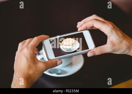 Donna di scattare una foto con il suo smartphone Foto Stock