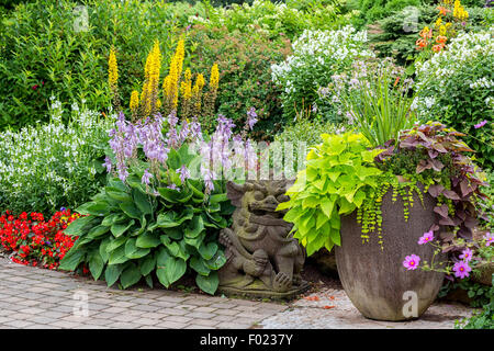 Dettaglio di un bellissimo giardino estivo con un interblocco passerella di pietra. Foto Stock