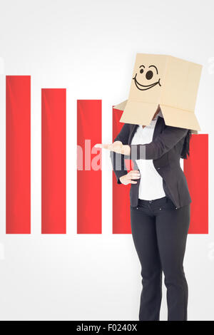Immagine composita di imprenditrice presentando con scatola sopra la testa Foto Stock