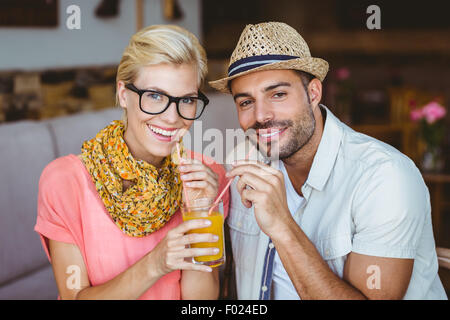 Carino coppia su una data la condivisione di un succo di arancia Foto Stock