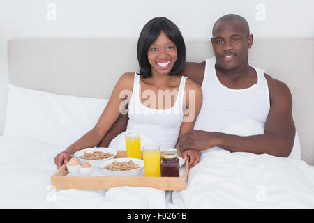 Ritratto di un bel giovane tenendo la colazione a letto insieme Foto Stock