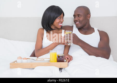 Piuttosto giovane tenendo la colazione a letto insieme Foto Stock