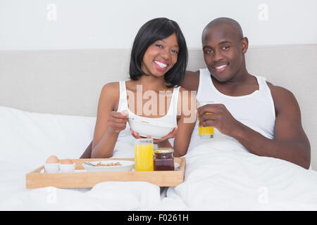 Ritratto di un bel giovane tenendo la colazione a letto insieme Foto Stock