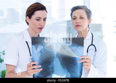 Concentrato colleghi medici esaminando x-ray insieme Foto Stock