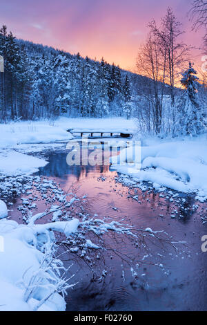 Un fiume congelato in un paesaggio invernale. Fotografato vicino a Levi in Lapponia finlandese a sunrise. Foto Stock