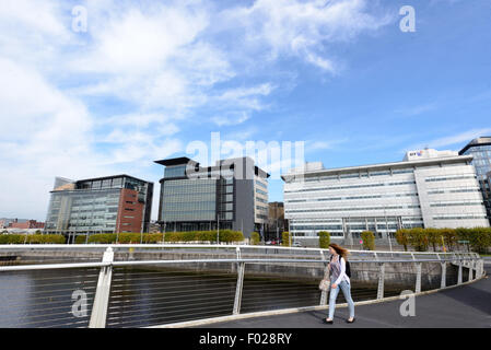 Una donna cammina attraverso il fiume Clyde a Glasgow sul ponte Broomielaw-Tradeston (noto localmente come il Ponte di sottolineatura ondulate). Foto Stock