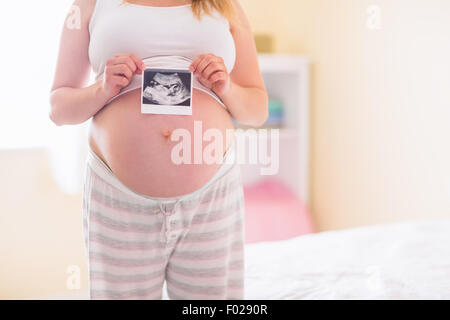 Donna incinta che mostra le scansioni a ultrasuoni Foto Stock