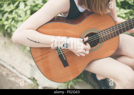 Close-up di una donna a suonare la chitarra Foto Stock