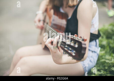 Close-up di una giovane donna a suonare la chitarra Foto Stock