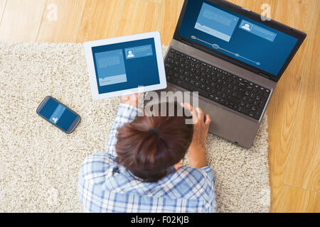 Immagine composita di brunette donna utilizzando il suo Tablet e notebook Foto Stock