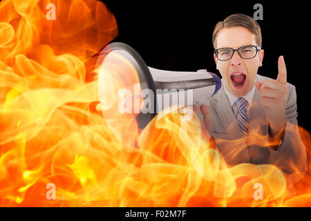 Immagine composita di geeky imprenditore urlando attraverso il megafono Foto Stock