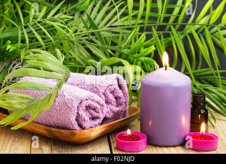 Spa.candele profumate, olio essenziale bottiglia e asciugamani di cotone sul verde sfondo Wellness Foto Stock