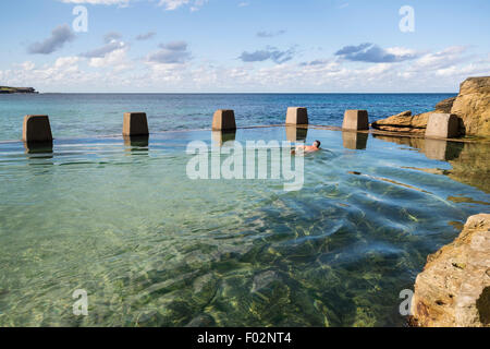 Uomo di nuoto in piscina vicino al mare, Ross Jones Memorial piscina, Coogee Beach, Sydney, Australia Foto Stock