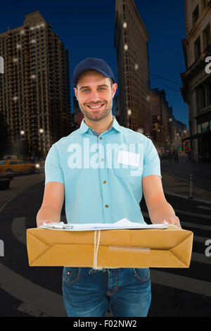 Immagine composita del corriere bello uomo con pacco Foto Stock