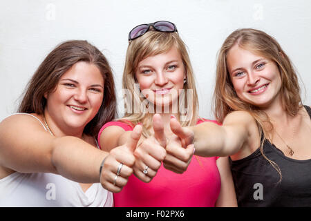 Un gruppo di giovani e felici amici dando il pollice in alto Foto Stock