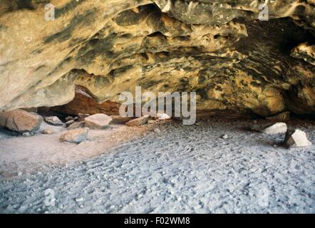 Grotta dove molti aborigeni dipinti di roccia possono essere trovati precedentemente utilizzato per cerimonie di iniziazione, Ayers Rock (Uluru), Uluru-Kata Tjuta National Park (Patrimonio Mondiale UNESCO, 1987), il Territorio del Nord, l'Australia. Foto Stock