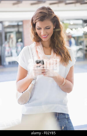 Donna sorridente utilizza lo smartphone Foto Stock
