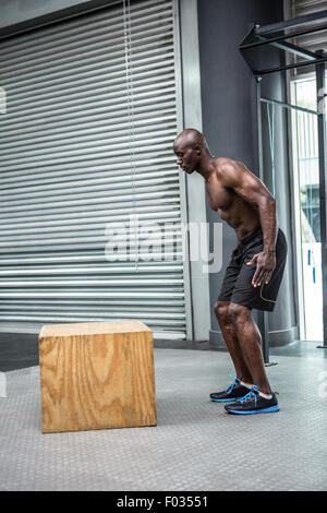 Giovani Bodybuilder in piedi di fronte a un blocco di legno Foto Stock