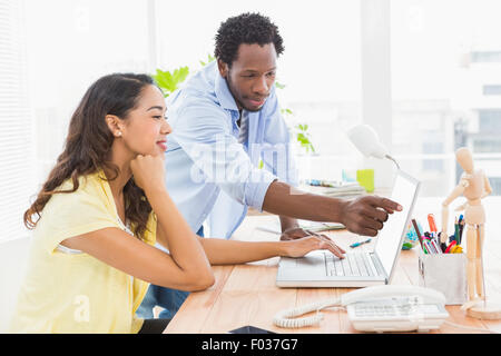 Giovane imprenditore che mostra una imprenditrice qualcosa Foto Stock