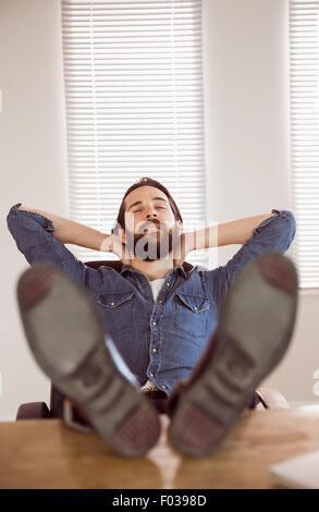 Hipster imprenditore di relax presso la sua scrivania Foto Stock