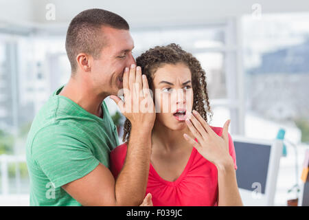 Imprenditore Casual whispering segreto per il suo collega Foto Stock