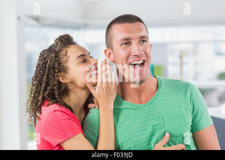 Casual imprenditrice whispering segreto al suo collega Foto Stock