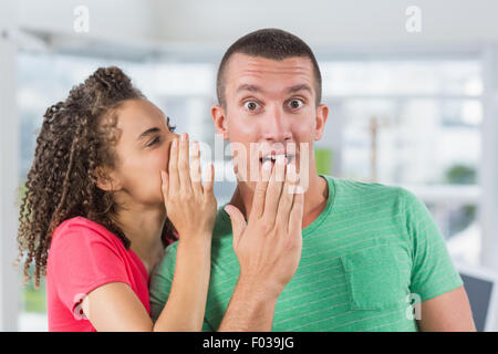 Casual imprenditrice whispering segreto al suo collega Foto Stock