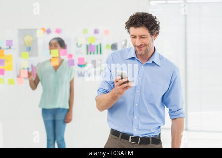 Imprenditore chiamando mentre il suo collega in posa Foto Stock