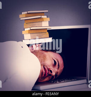 Immagine composita di imprenditore appoggiato la testa sulla tastiera del notebook Foto Stock