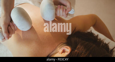 Giovane donna getting herbal comprimere massaggi Foto Stock