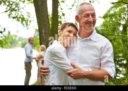 Coppia senior in amore abbracciando nella natura in estate Foto Stock