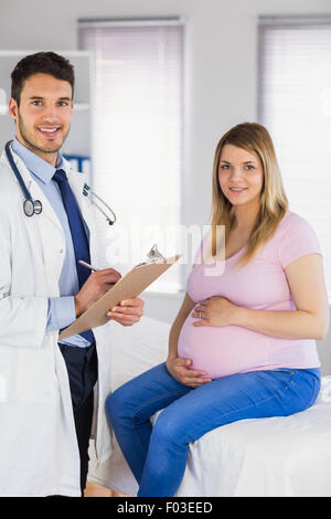 Ritratto di sorridere medico e la sua paziente in stato di gravidanza Foto Stock