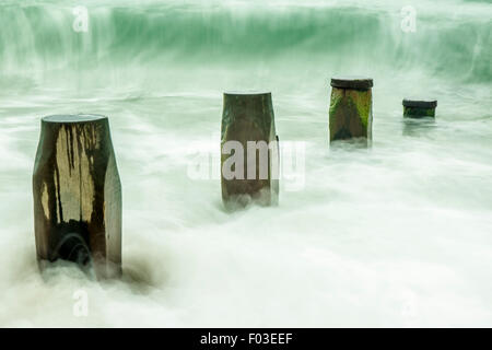 Le difese di spiaggia a Hayling Island con onde in movimento Foto Stock