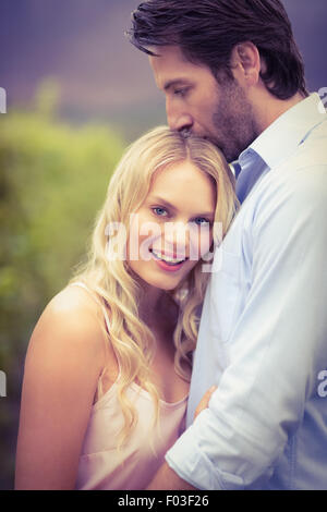 Giovane uomo felice kissing donna sulla fronte Foto Stock