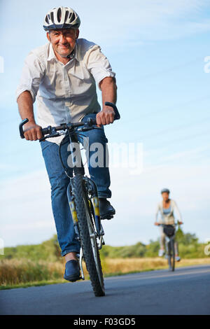 Personale senior con caschi moto escursioni in bicicletta in estate Foto Stock