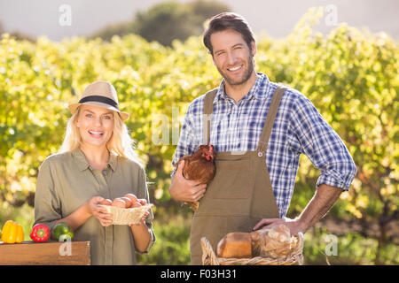 Sorridente imprenditore giovane azienda pollo e uova Foto Stock