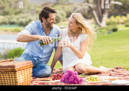 Carino coppia sulla data versando il vino in un bicchiere Foto Stock