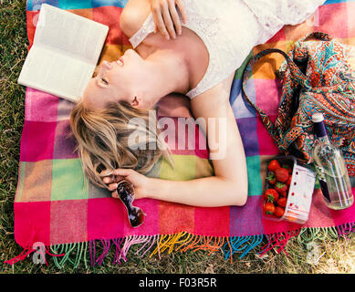 Donna sdraiata sulla coperta in estate Foto Stock