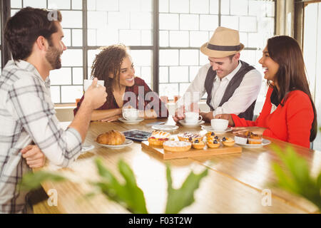 Ridere gli amici sorseggiando caffè e tratta Foto Stock