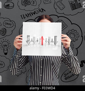 Immagine composita di imprenditrice che mostra una carta bianca di fronte il suo volto Foto Stock