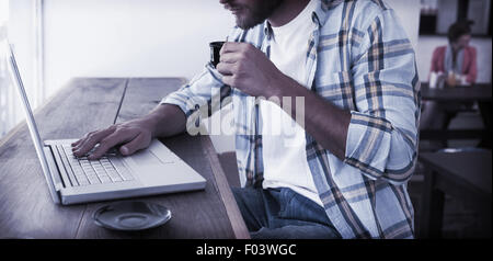 Uomo informale utilizzando laptop di bere caffè espresso Foto Stock