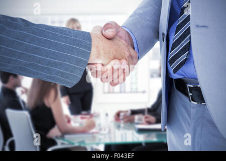 Immagine composita di imprenditore stringono le mani con un lavoratore di co Foto Stock