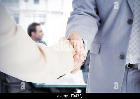 Immagine composita di persone in tuta stringono le mani Foto Stock