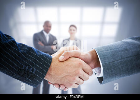 Immagine composita di uomini di affari che stringono le mani Foto Stock